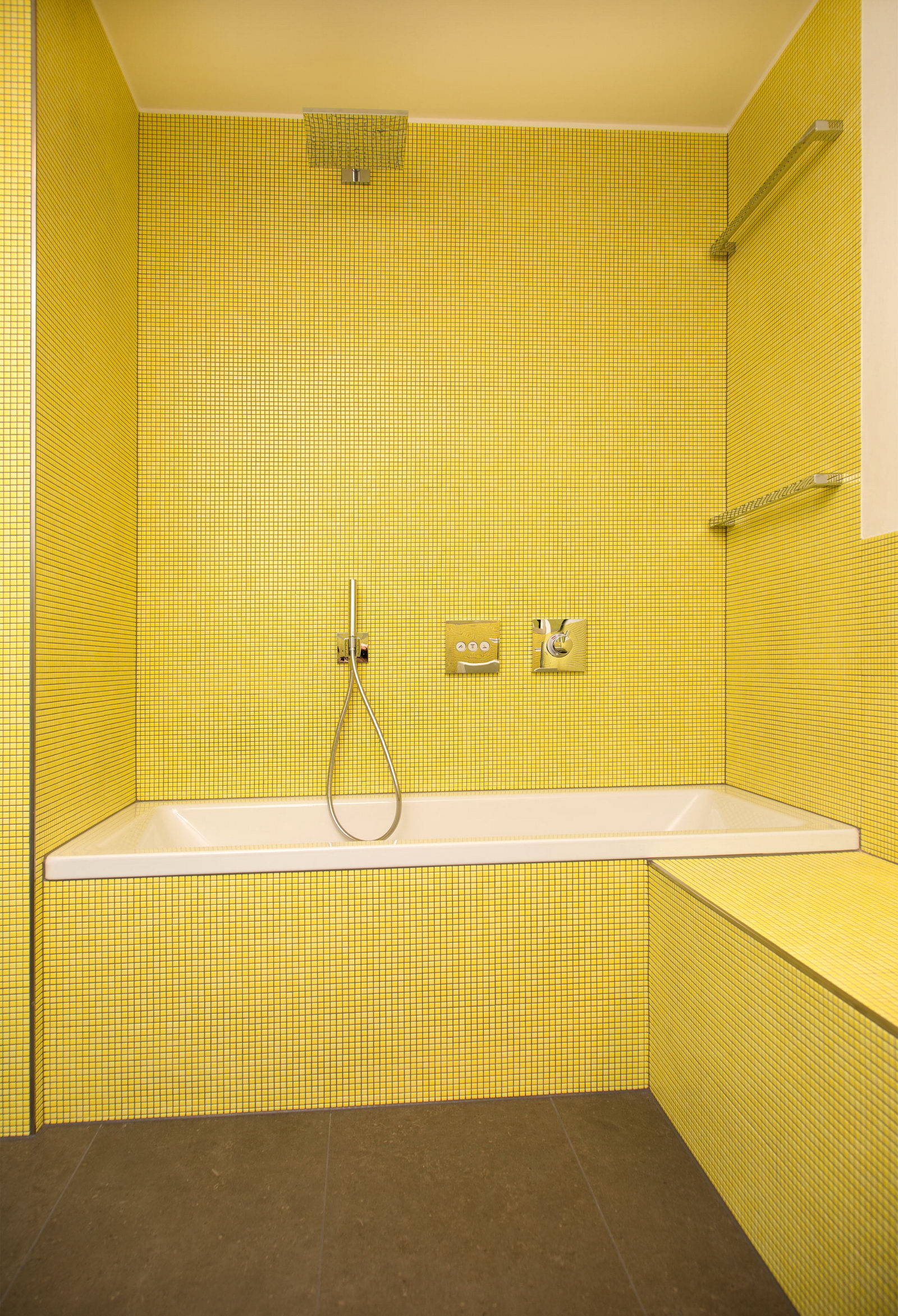 Gestalten mit Farbe - Die Badewanne sticht aus dem gelben Keramikmosaik hervor